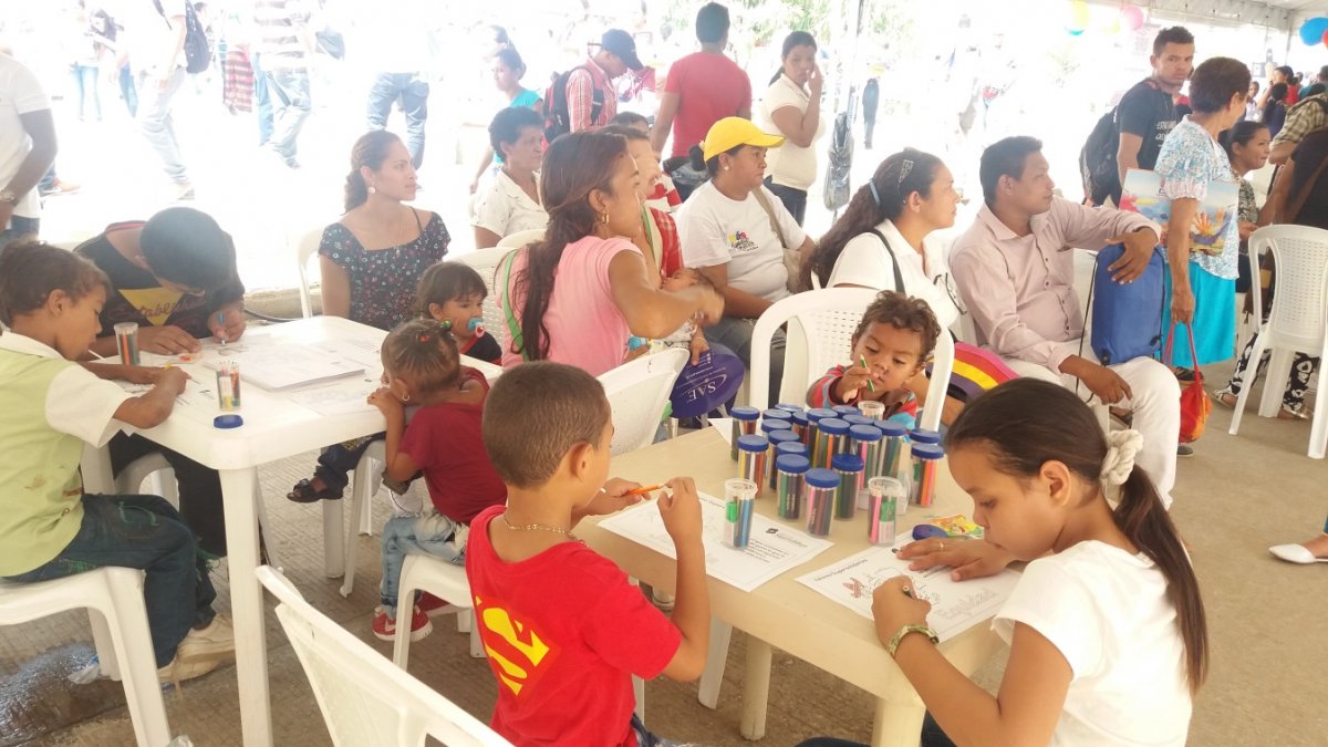 Los niños coloreando los valores de Supersolidaria mientras sus padres participan de actividad lúdica